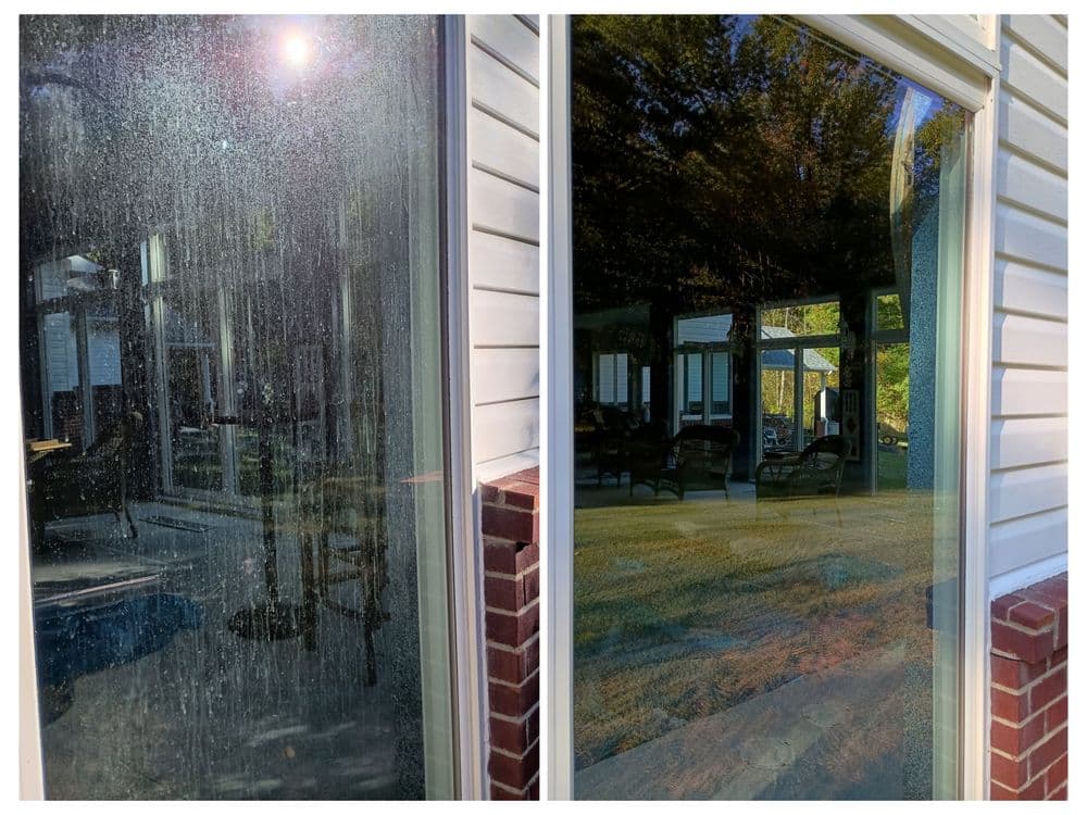 Dirty window reflecting a patio and outdoor furniture in natural light.